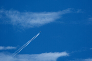 Contrail and clouds. Airplane trail in the blue sky with white clouds and copy space