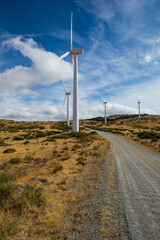 Wind turbines create clean energy in a scenic landscape with clear skies and rolling hills