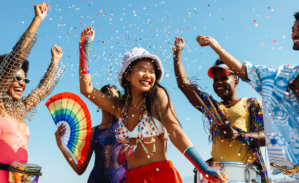 Fototapeta People celebrate at colorful carnival outdoors