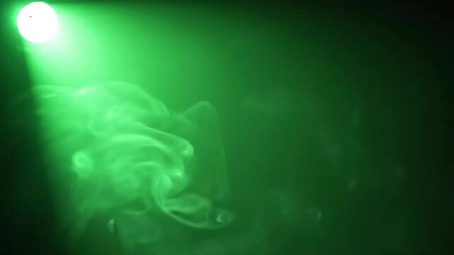 Mysterious green smoke and light mist swirling in the dark. Ideal for abstract design, motion graphics, and cinematic backgrounds.
