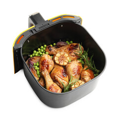Air fryer basket with grilled chicken drumsticks, spices and green peas isolated on white, above view