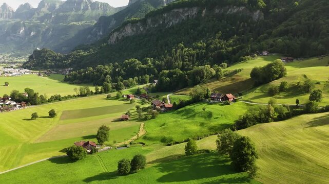 Aerial Drone View of the Swiss Alpine Valley with Green Fields, Rolling Hills, and Majestic Mountains near Flums, Berschis, and Walenstadt in the Canton of St. Gallen, Switzerland
