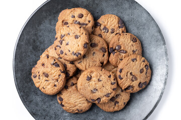 Baked chocolate chip cookies on black plate isolated on white background
