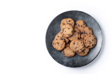 Baked chocolate chip cookies on black plate isolated on white background. Top view. Copy space