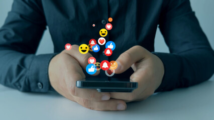 Social media,marketing, like,social network,blog,live,chat reaction and livestream.Person using smart phone with emoticon icons of Social Media.Interactive with friends on chat with emoticon feedback.