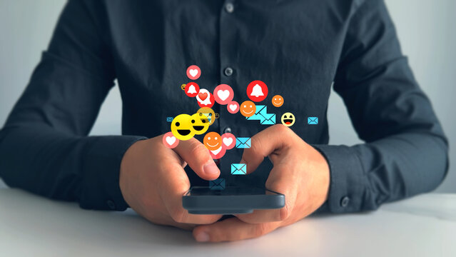 Person using smart phone with emoticon icons of Social Media.Interactive with friends on chat with emoticon feedback.Social media,marketing, like,social network,blog,live,chat reaction and livestream.
