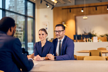 Fototapeta premium Real Estate Meeting At Modern Café: Couple Discusses Documents And Plans Over Coffee