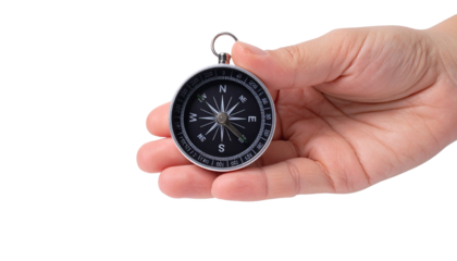 A hand holds a compass, guiding direction