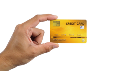 A hand holding a credit card