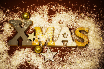 Xmas letters in snow with golden decorations