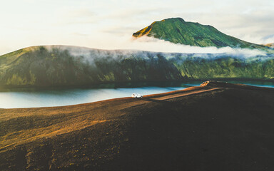 Hnausapollur, Iceland - 30 August 2025: Aerial view of the stunning contrast between the dark volcanic earth and the vivid green mountains, all embraced by a serene, misty sky.