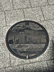 Decorative manhole cover with architectural design in urban street