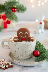 A gingerbread man is sitting in a cup of hot chocolate