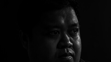 Black and white side portrait of a man looking away with deep expression, representing...