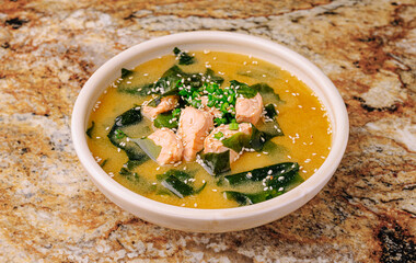 Delicious bowl of soup with chicken and seaweed on granite countertop