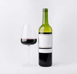 Elegant wine bottle and glass showcasing rich red wine in a minimal setting