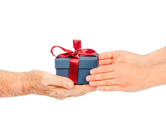 Elderly and young hands exchanging a small blue gift box with a red ribbon, isolated on white. Concept of care, giving, gratitude connection between generations during holidays. special occasions.