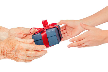 Close-up of elderly and young hands exchanging a blue gift box with a red ribbon, isolated on...