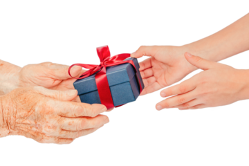 Close-up of elderly and young hands exchanging a blue gift box with a red ribbon, isolated on white. Symbolic concept of giving, care, gratitude, connection, family love between generations.