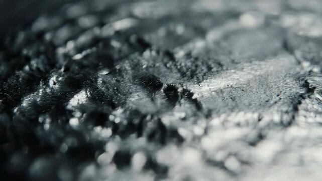 Macro shot of metallic rock surface with detailed texture and reflective patterns under soft light.