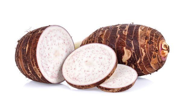 A close-up, isolated shot of taro root, showing the whole root and sliced sections on white