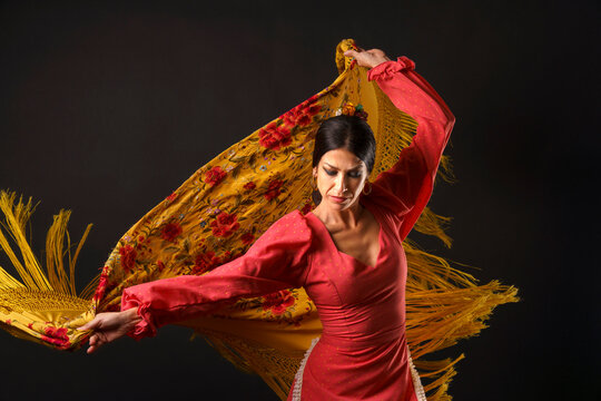 Flamenco dancer performing soulful dance, twirling traditional Spanish manton shawl with passion