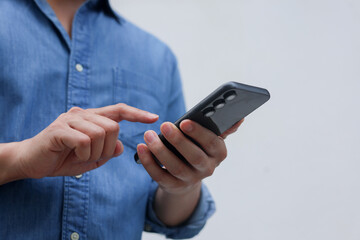 close up businessman hand hold smartphone to surfing the internet and check work or mail on website while sit in the living room in weekend for business technology and lifestyle concept