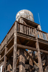 Wooden water tower structure against a clear blue sky on a sunny day in a rural area