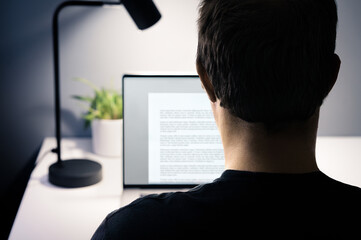 Write blog content with laptop computer. Writer of text, essay, letter, book or report document. Copywriter, editor, freelance journalist or author. Back of man in focus.