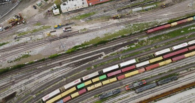 Aerial view of a sprawling network of railway tracks with colorful freight train cars, a tableau of industrial activity, Trieste, Friuli-Venezia Giulia, Italy.