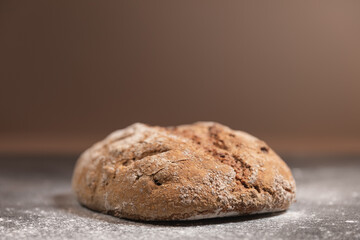 Close-up rustic whole grain walnut bread on floured dark slate with light gray background
