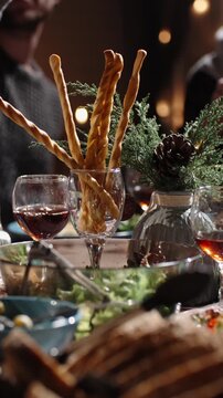 Vertical slow motion video close up of hands raising wine glasses over festive table cozy light atmosphere concept family celebration friendship gratitude warm home lifestyle evening