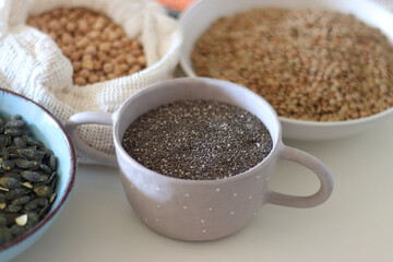 Bowls and bags full of various healthy grains and legumes. Selective focus.