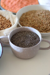 Bowls and bags full of various healthy grains and legumes. Selective focus.