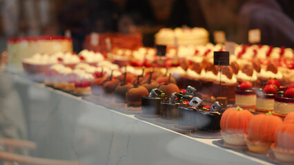 Chocolate cakes and creamy desserts in glass window of bakery