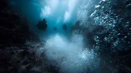 Fototapeta premium Three scuba divers ascend through a sunlit underwater world surrounded by a cloud of rising bubbles