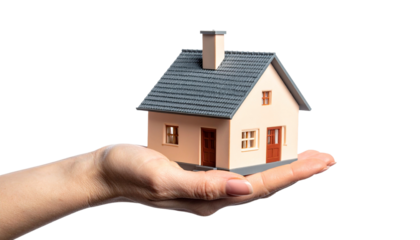 A miniature house delicately held in a human hand, showcasing the concept of home ownership and property