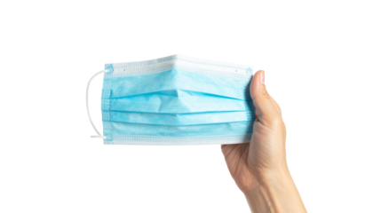 A hand holding a blue surgical mask, highlighting health safety measures and protection from illness