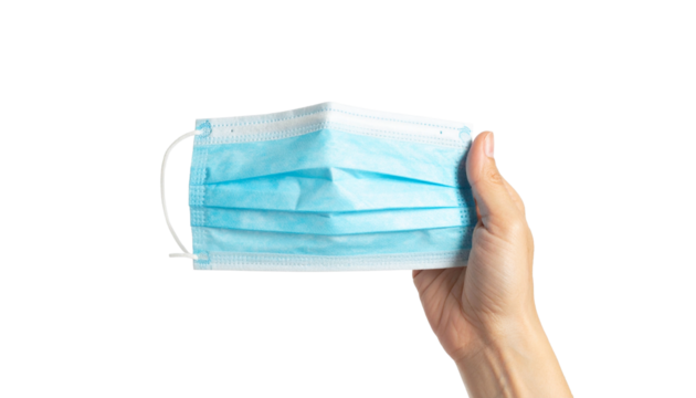A hand holding a blue surgical mask, highlighting health safety measures and protection from illness