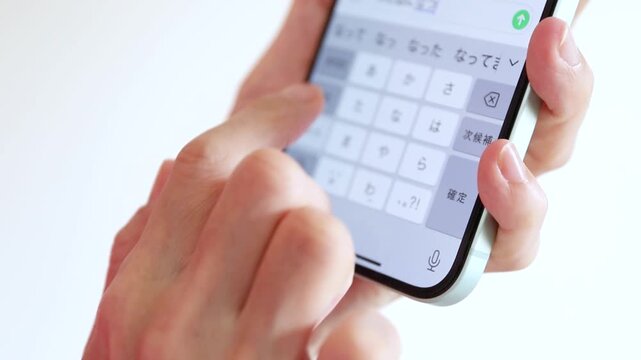 スマートフォンでテキスト入力をする手元