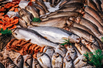 Large assortment of fish and seafood are displayed in a market.