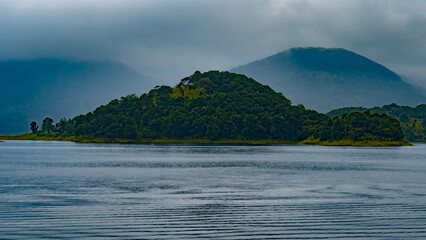 Solitude in Emerald Stillness – Landscape Of a Single Island In the Middle Of A Lake