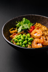 Delicious bowl of shrimp and noodle dish with fresh vegetables and toppings