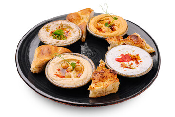 Delicious Middle Eastern dips with pita served on a dark plate