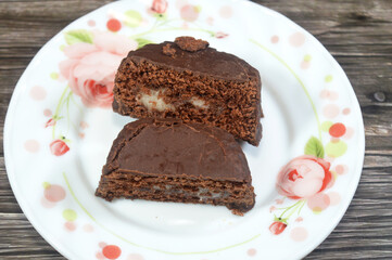 two halves of a chocolate cake, a cake flavored with melted chocolate, cocoa powder and coated with chocolate and filled with a cream fillings, Chocolate brownie, pastries with a dense texture