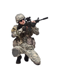A soldier in camouflage clothing stands on one knee and fires a rifle