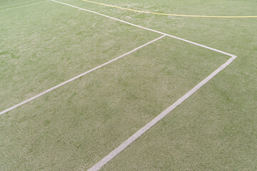Artificial green turf with white painted lines on a open sports field