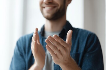 Smiling man clapping hands in appreciation, showing support and encouragement.