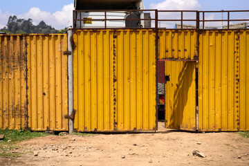 Kiambu County, Kenya - October 13th 2025 - Yellow metal fence container