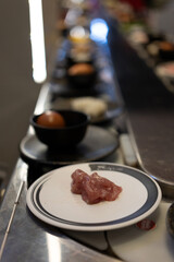 Conveyor Belt Shabu-Shabu with Raw Meat Plate in Focus